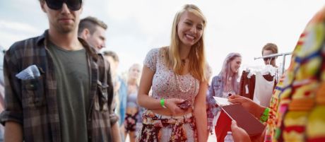 Junge Frau bezahlt auf einem Festival mit Kreditkarte